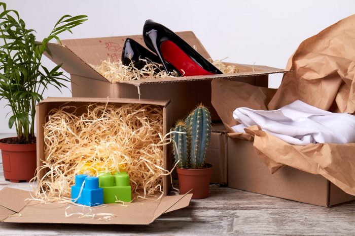 Boîtes déballées contenant des chaussures, des vêtements et des jouets Goldcolis. Acheter des colis perdus, c’est découvrir des articles inattendus et utiles